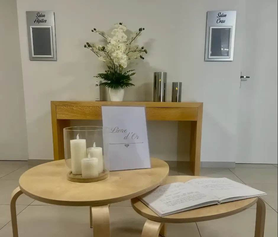 Espace d'accueil funéraire avec livre d'or et bougies allumées.